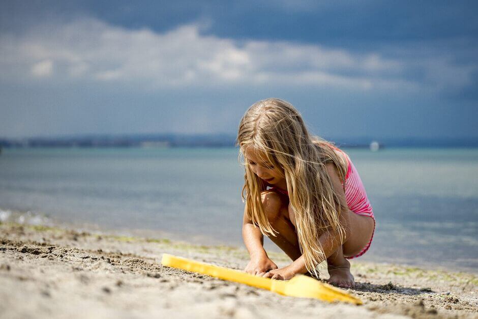 Dziewczynka bawiąca się w piasku na plaży