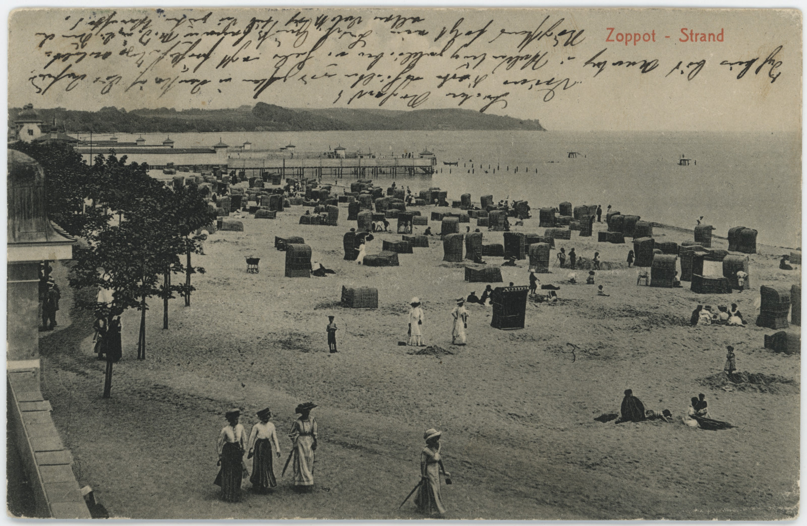 Panie w sukniach na plaży w Sopocie - na starej pocztówce